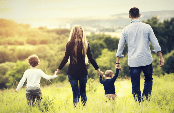 Family holding hands in grass