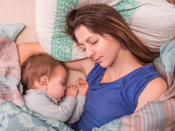 woman sleeping with her infant