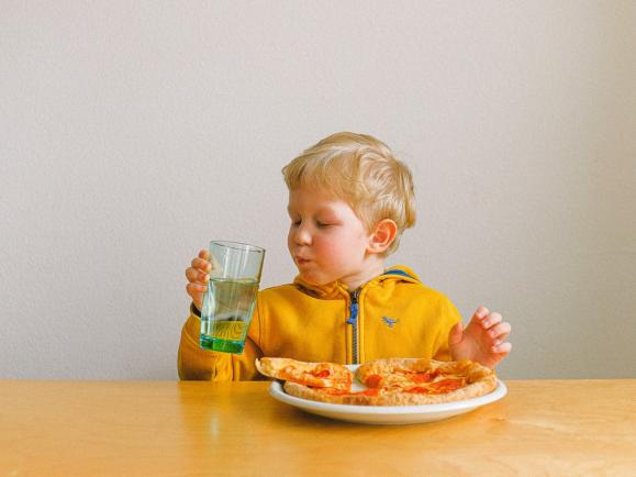 child eating pizza